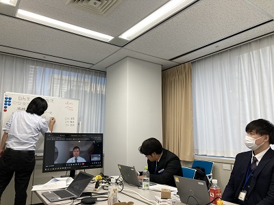 講師がホワイトボードを使用して新入社員を研修している様子。